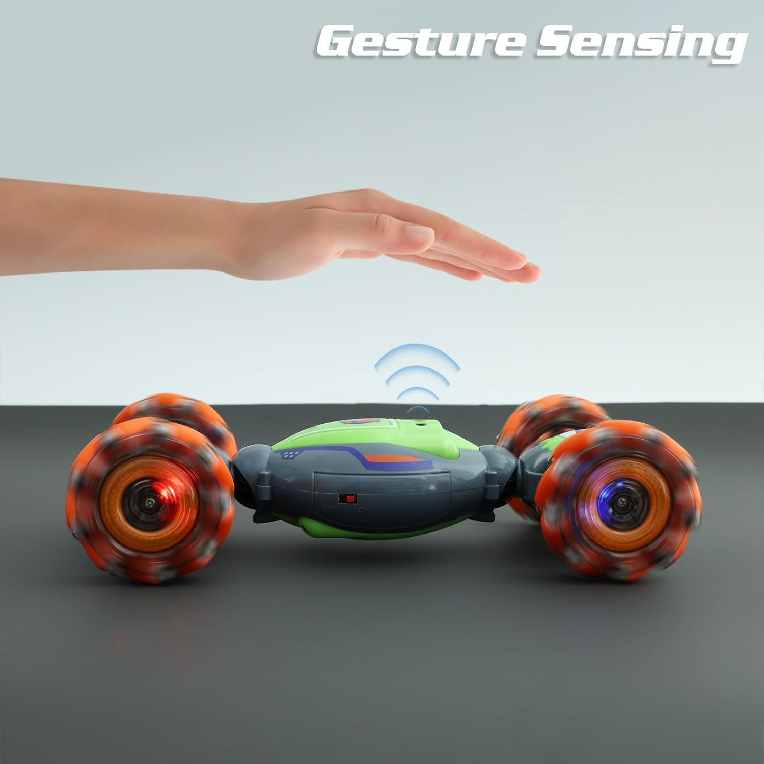 QXHOL green and orange gesture-sensing stunt car with hand control feature in action.